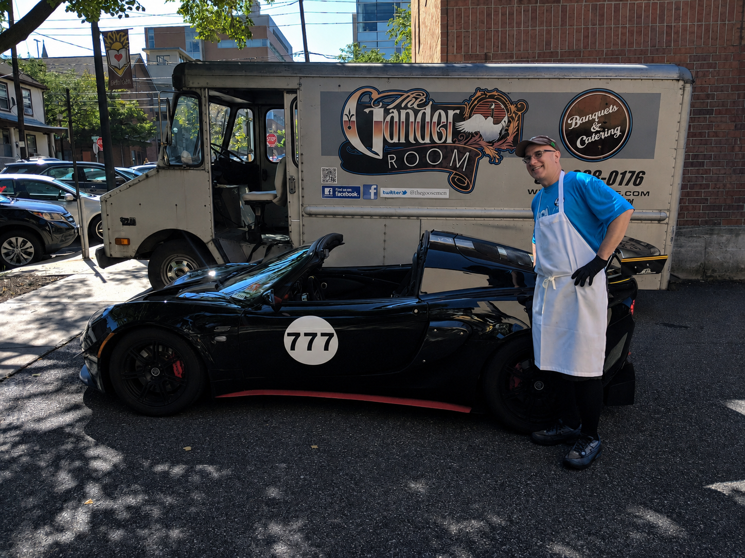 Lotus Exige number 777 parked beside The Gander Room food truck with Tony Silvoy of The Goose deli standing next to the car in his white apron