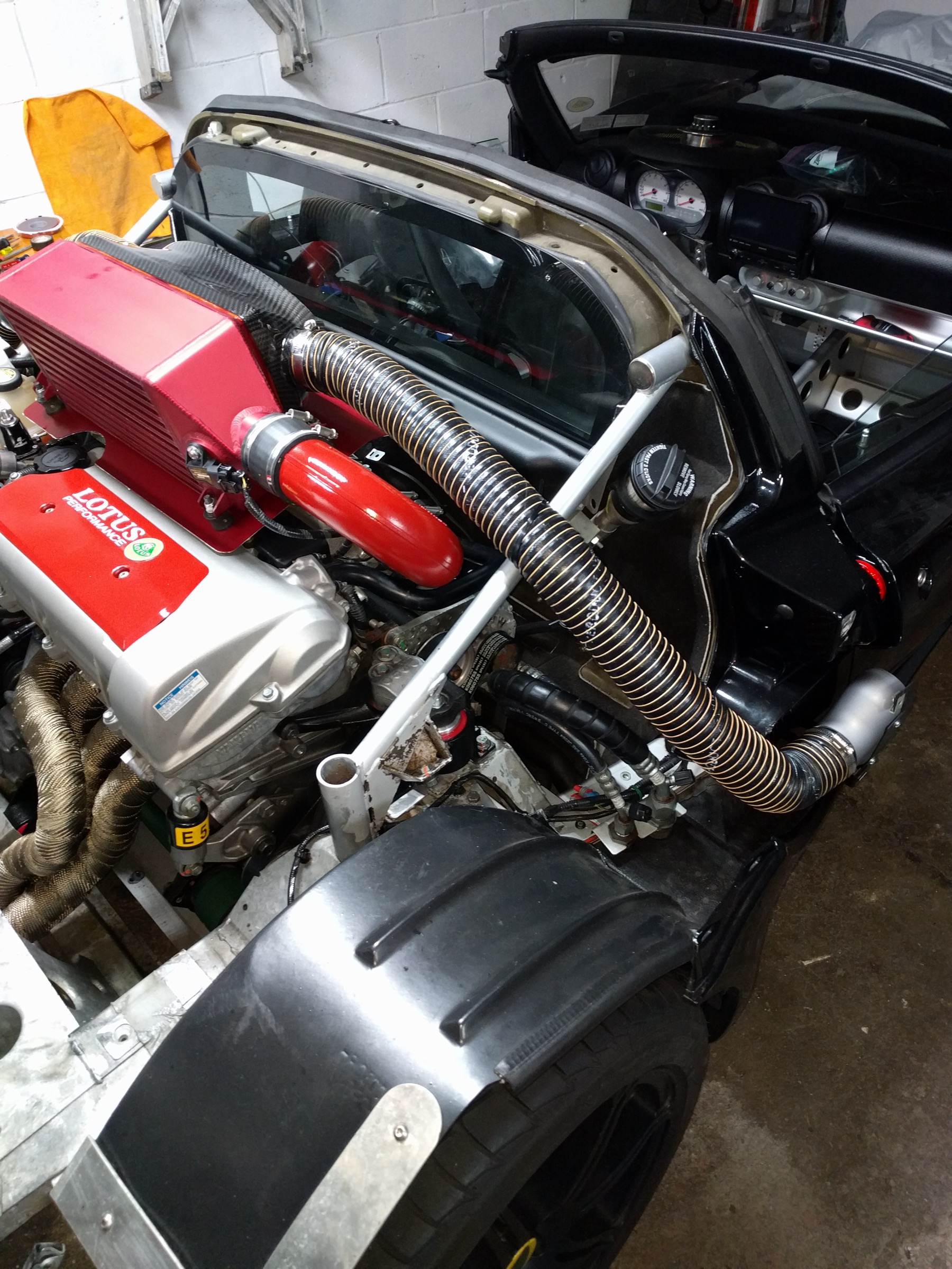 Charge-air ducting and wrapped exhaust packed tightly into the Lotus engine bay