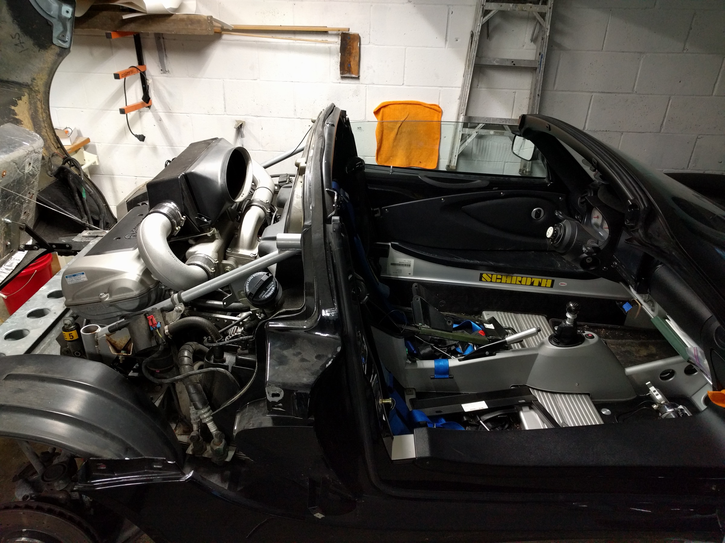 Lotus Exige mid-disassembly — rear clam lifted, seats removed